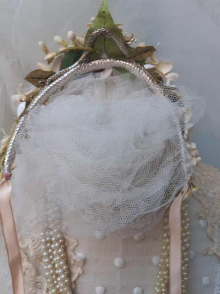 A blush pink handmade bridal headdress hand crafted with antique and vintage flowers and leaves