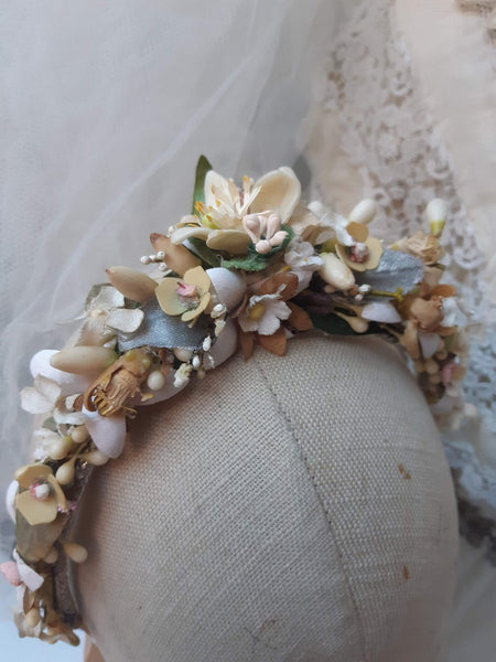 A blush pink handmade bridal headdress hand crafted with antique and vintage flowers and leaves