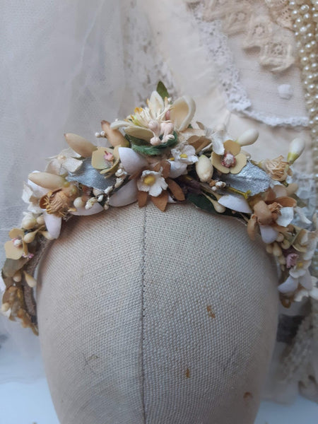 A blush pink handmade bridal headdress hand crafted with antique and vintage flowers and leaves