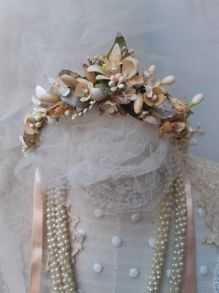 A blush pink handmade bridal headdress hand crafted with antique and vintage flowers and leaves