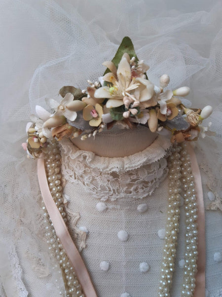 A blush pink handmade bridal headdress hand crafted with antique and vintage flowers and leaves